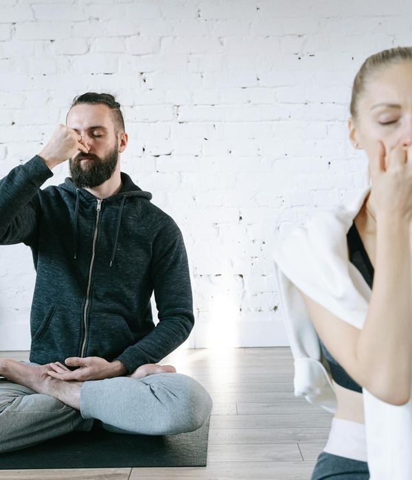Woman in a calm yoga pose in a bright, serene room.